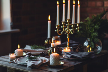 Elegant decor for Christmas family dinner. Center piece with burning candles, vintage chandelier....