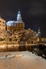 Winter view of Cesky Krumlov, picturesque houses under the castle with snow-covered roofs. Narrow streets and the Vltava river. Travel and Holiday in Europe. UNESCO World Heritage. Czechia