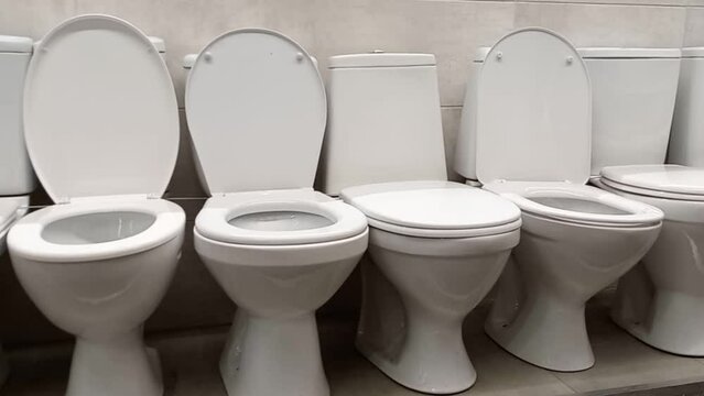 Various toilet bowls on the shop window. Wholesale and retail trade of sanitary ware. Different toilet bowls in the toilet and in the bathroom