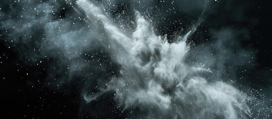 A high-speed photograph capturing the dramatic moment of a white dust explosion frozen in time against a stark black background. The chaotic dispersal of particles creates a dynamic and captivating