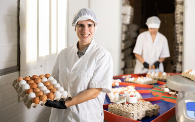 group of adult highly skilled workers carry out quality control on eggs in chicken farm © JackF