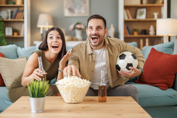 Couple cheers for soccer match from home - 748341972