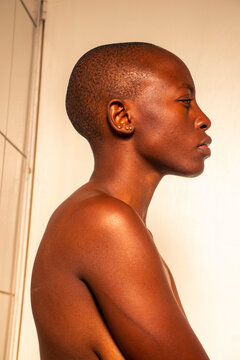 Side profile of a young black woman with a shaved head