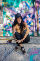 Portrait of a happy skater girl with tattoos at a skate park - 748346772