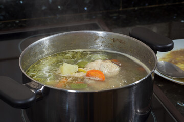 Cooking vegetable broth, with chicken, potato, carrot, green beans and extra virgin olive oil.