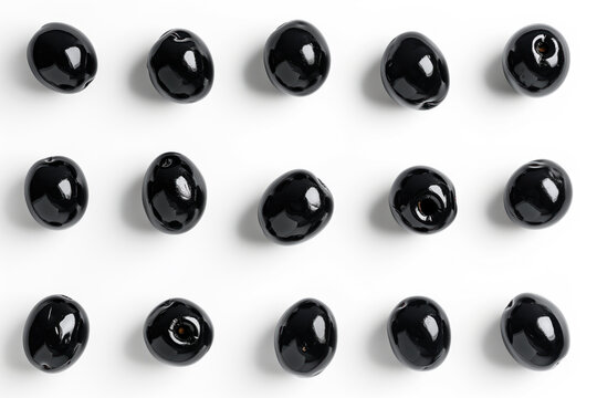 A minimalist composition featuring glossy black olives on a white background.