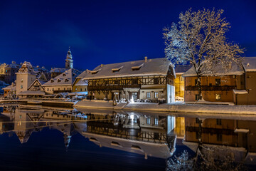 Fototapeta na wymiar View of Czech Krumlov in winter, Czech Republic. Picturesque houses under the castle with snow-covered roofs. Narrow streets and the Vltava river. Travel and Holiday in Europe. UNESCO World Heritage.