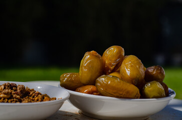 Dates bowl closeup on dark background with writing space and Sfouf cake bowl, Ramadan iftar, meals 