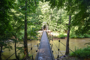 wooden bridge in the woods over river