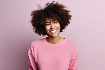 Portrait of a smiling young african american woman over pink background