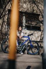 A reflective woman rests on her bike amidst the bustle of city life, capturing a moment of...