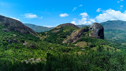 Fototapeta na wymiar A breathtaking scene of a majestic mountain range surrounded by lush green trees and bushes, creating a tranquil and picturesque landscape.