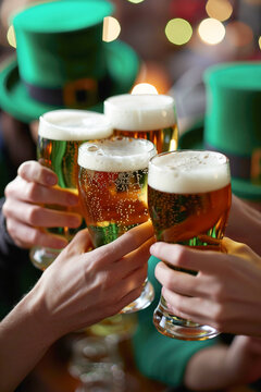 Four people toast with beer pint at the bar for St. Patrick's Day. Close up vertical image
