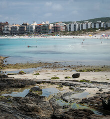 Praia do Forte, with lots of rocks, people walking, located in the city of Cabo Frio, Rio de Janeiro.