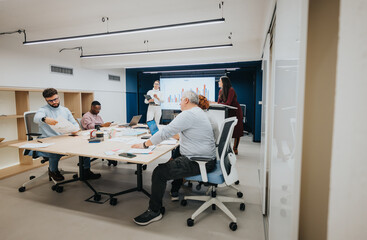 Different aged businesspeople collaborate in a dynamic workshop, discussing stats and sharing ideas for profit growth and successful strategies.