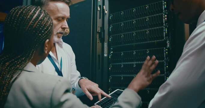 Team, tablet programming and server room for planning, digital screen coding or cloud computing solution. Manager, technician or group of people in data center for system or hardware problem solving - Powered by Adobe