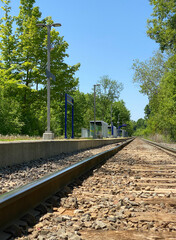 Obraz premium Train station. Boarding quay and train shelters. Railroad tracks in the countryside. Public railway station. Waiting area for public transport. Arrival city notice board.