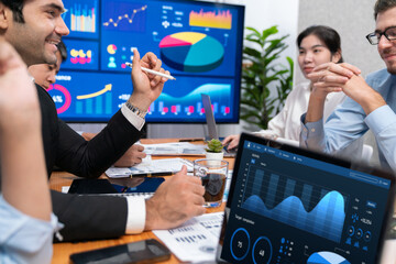Fototapeta premium Diverse group of business analyst team analyzing financial data report. Finance data analysis chart and graph dashboard show on TV screen in meeting room for strategic marketing planning. Habiliment