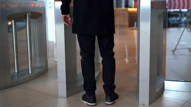 Businessman entering office building trough security gates. Media. Man passing through the turnstile.