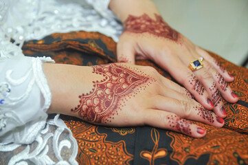 two hands decorated with henna art