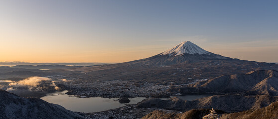 Panoramic view of snow-capped Mt. Fuji and Kawaguchiko-lake at sunrise.