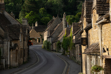 Charming old stone terraced houses along a winding road in Castle Combe