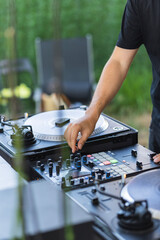 Hand of a DJ on the buttons of the mixing console during a party