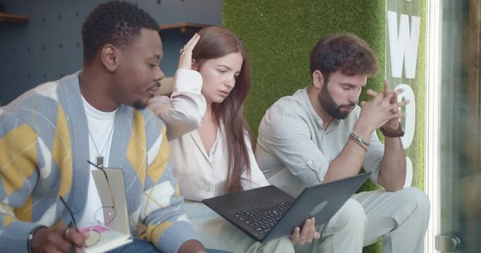 Things went wrong. Three business coworkers working together and struggling with their tasks while sitting on threshold at the office. They did a big mistake and cannot believe it