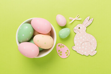 Easter bunny with eggs on color background, top view