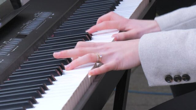 Fragile tender female hands playing a synthesizer outside in the cold season