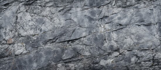 An elevated view of a black and white rugged granite rock wall, showcasing the natural texture and patterns of the stones.