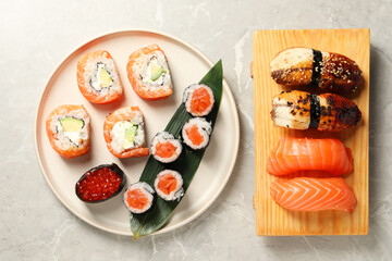 Delicious sushi rolls on white background, flat lay