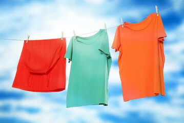 Different clothes drying on washing line against blue sky