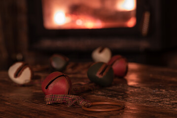 Colourful Christmas ornaments in front of cozy fire.