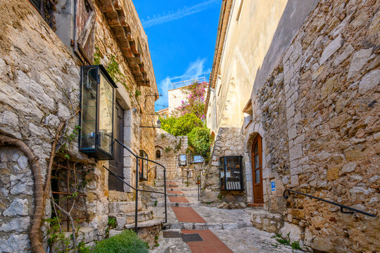 Fototapeta A picturesque stone alley with steps in the historic medieval village of Eze, France, along the Cote d'Azur French Riviera of Southern France.