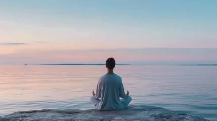 Foto op Canvas Woman meditating at peaceful lake seaside calming concept © The Stock Image Bank