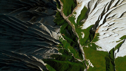 Aerial top down view of a mountain top. Clip. Green summer grass and white stony slopes. © Media Whale Stock