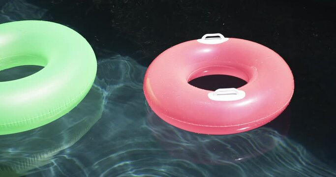 Two colorful swim rings float on the water's surface