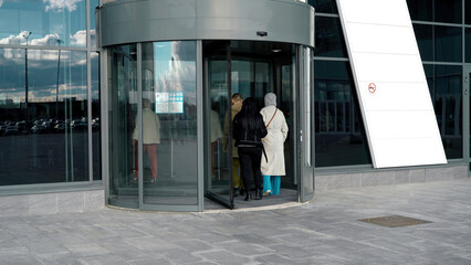 A revolving door in modern building, shopping center. Media. Glass rotating door, turntable...