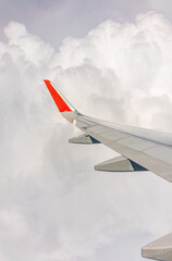 View from the airplane window at a beautiful cloudy sky and the airplane wing