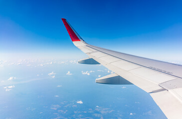 Obraz premium View from the airplane window at a beautiful cloudy sky and the airplane wing