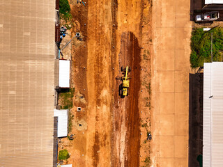 Aerial view yellow grader building a highway, Grader that is making roads and adjusting the area at the construction site. Bulldozer working at road construction. Compactor roller