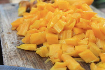 Jackfruit slices on a wooden chopping board on the table