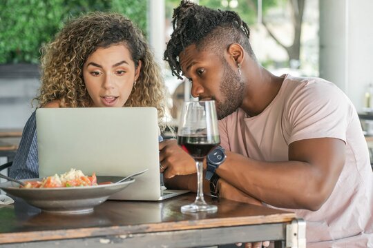 Couple Using Laptop While Having Lunch Together