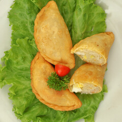 Obraz premium Pastel in Indonesia refers to a type of kue filled with shrimp, vegetables, egg and deep fried in vegetable oil. It is consumed as a snack and commonly sold in Indonesia traditional markets. 