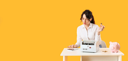 Young woman counting money on yellow background