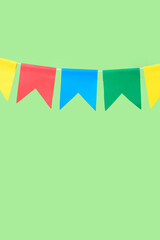 Colorful flags for Festa Junina on green background