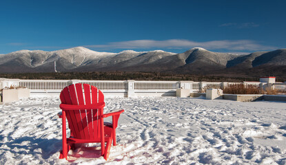 one red chair overlooking Mount Washington and the presidential range of the White Mountains