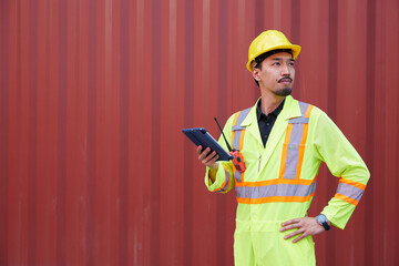 worker or engineer checking product from tablet in containers warehouse storage