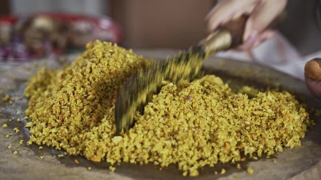 a Person is do chopping Balinese Herb Seasoning with Blakas, a Traditional Balinese Knife on the Wooden Board